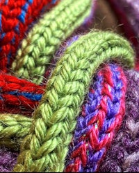 a close up of a colorful knitted ball