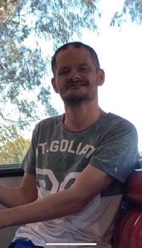 a man sitting on a bus with a smile on his face