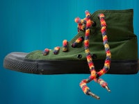 a green sneaker with colorful yarn tied to it