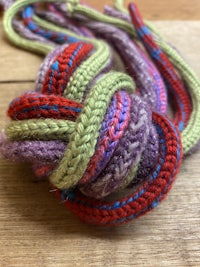 a colorful crocheted knot on top of a wooden table