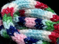 a colorful crocheted bracelet on a black surface